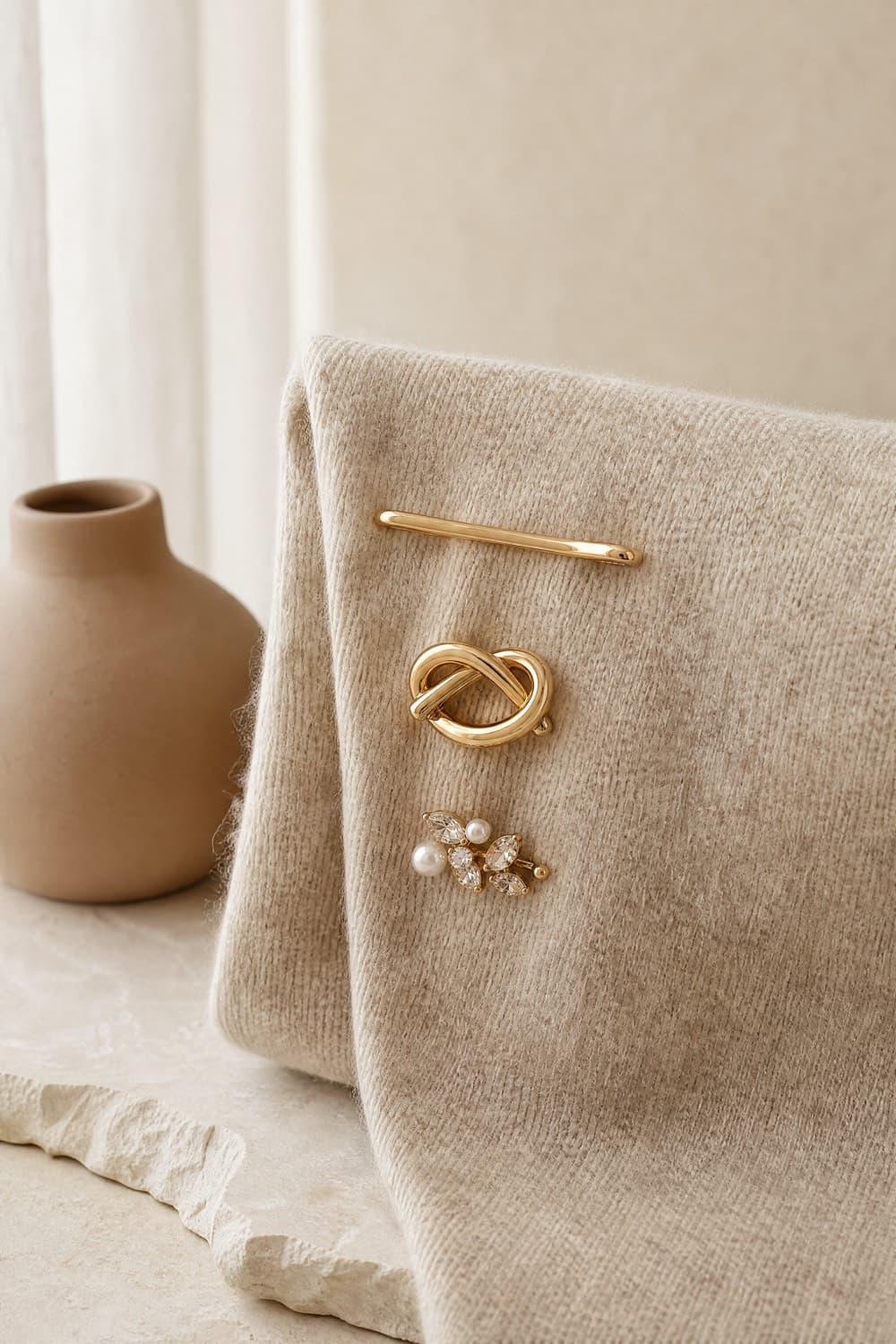 Three gold-tone brooches with glass and pearl-look detail on fabric