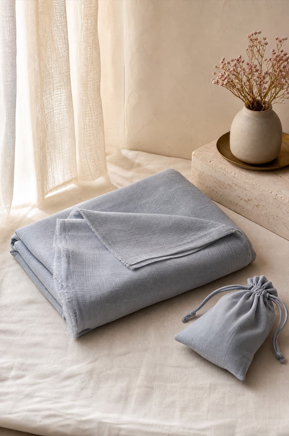 Soft grey modal wrap folded loosely on a pale linen surface
