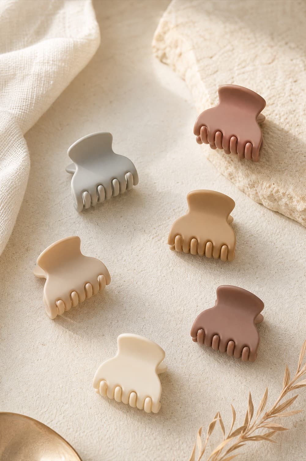 Six mini claw clips scattered on a pale surface