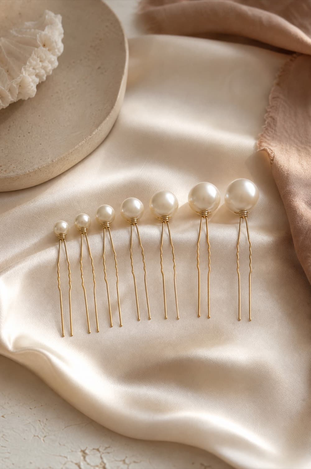 Eight pearl-topped hair pins laid out in ascending size order